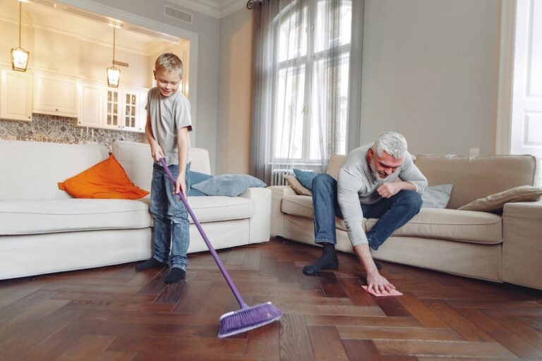 Sweeping hardwood floors in Wilmington, NC to prevent scratches.